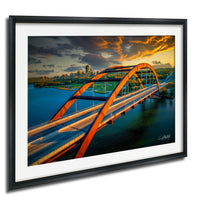 a large, orange bridge spanning across a body of water, with a city skyline visible in the background.