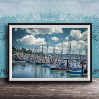 A framed photograph of a harbor with numerous sailboats docked in the water, set against a backdrop of a cloudy sky.