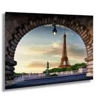 the Eiffel Tower, a famous landmark in Paris, France, captured from a perspective under an archway. The tower is visible in the background, with a clear sky and a colorful sunset in the foreground.