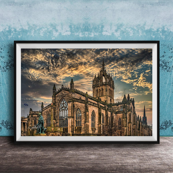 A framed photograph of a large, ornate cathedral with a castle-like structure, set against a dramatic sky with clouds and a sunset.
