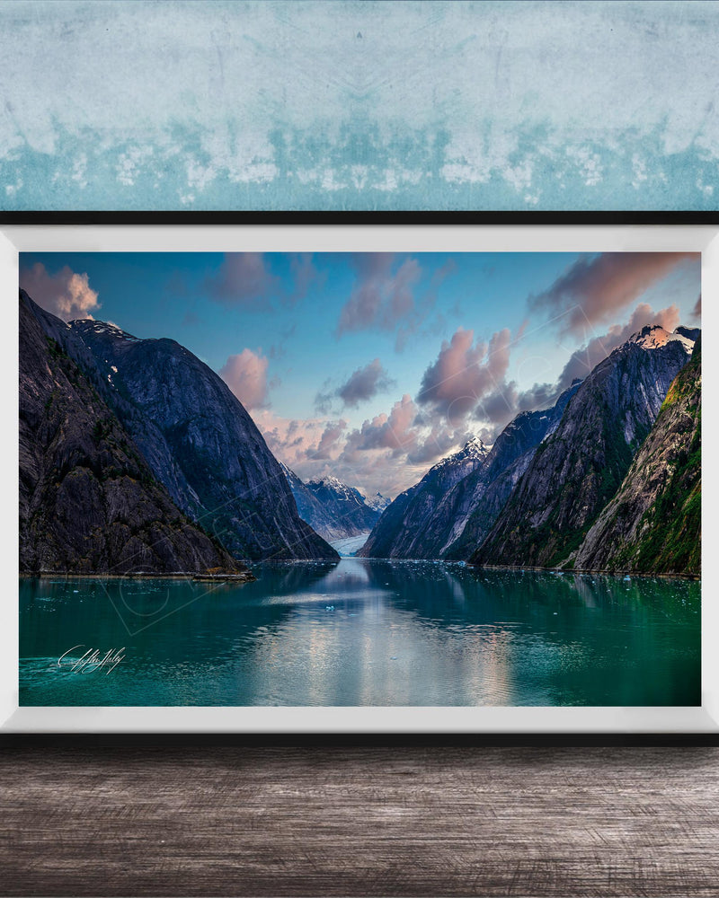The image is a framed photograph of a serene mountain lake, with a stunning view of the mountains and the calm waters reflecting the sky.
