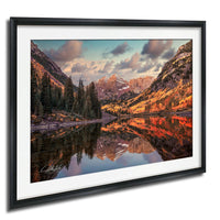 a serene mountain landscape with a lake reflecting the vibrant colors of the surrounding trees and mountains.