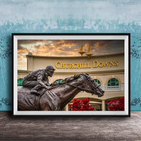 A bronze statue of a jockey riding a horse in front of a building with the sign " Churchill Downs" displayed.
