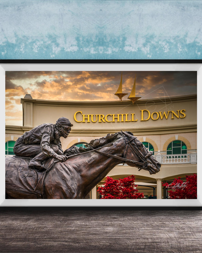 A bronze statue of a jockey riding a horse in front of a building with the sign " Churchill Downs" displayed.
