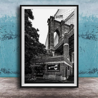 A black and white photograph of the Brooklyn Bridge, with the name 'LOOKS LOBSTER' displayed on the building.