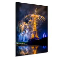 a nighttime scene with a large tower illuminated by bright lights, surrounded by a vibrant display of colorful fireworks in the sky.