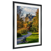 A framed photograph depicting a scenic path winding through a park, with a castle-like building visible in the distance.