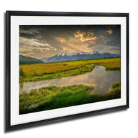 a serene landscape with a river, mountains, and a cloudy sky.