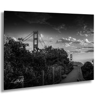 A black and white photograph of the Golden Gate Bridge in San Francisco, California, with a cloudy sky in the background.