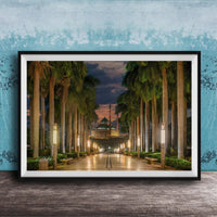 A framed photograph depicting a serene nighttime scene of a palm-lined walkway leading to a building, with the sky illuminated by the warm glow of the setting sun.