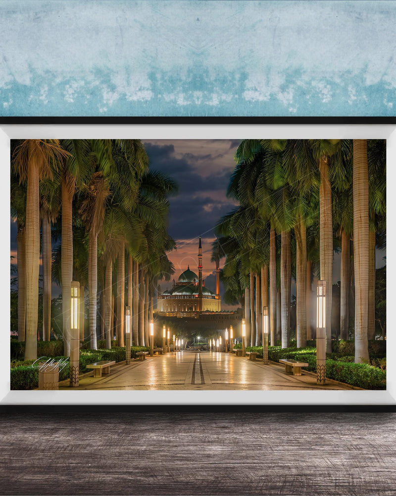 A framed photograph depicting a serene nighttime scene of a palm-lined walkway leading to a building, with the sky illuminated by the warm glow of the setting sun.