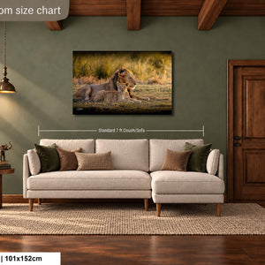 a living room with a large painting of a lion and its cub hanging on the wall. The painting is approximately 40 inches wide and 115 centimeters tall. The room has a wooden floor and a beige sofa with throw pillows. There is also a wooden side table and a lamp in the room.