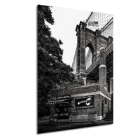 A black and white photograph of the Brooklyn Bridge, with a lobster restaurant visible on the side of the bridge.