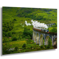 A steam train travels along a stone viaduct, surrounded by lush green hills and trees.