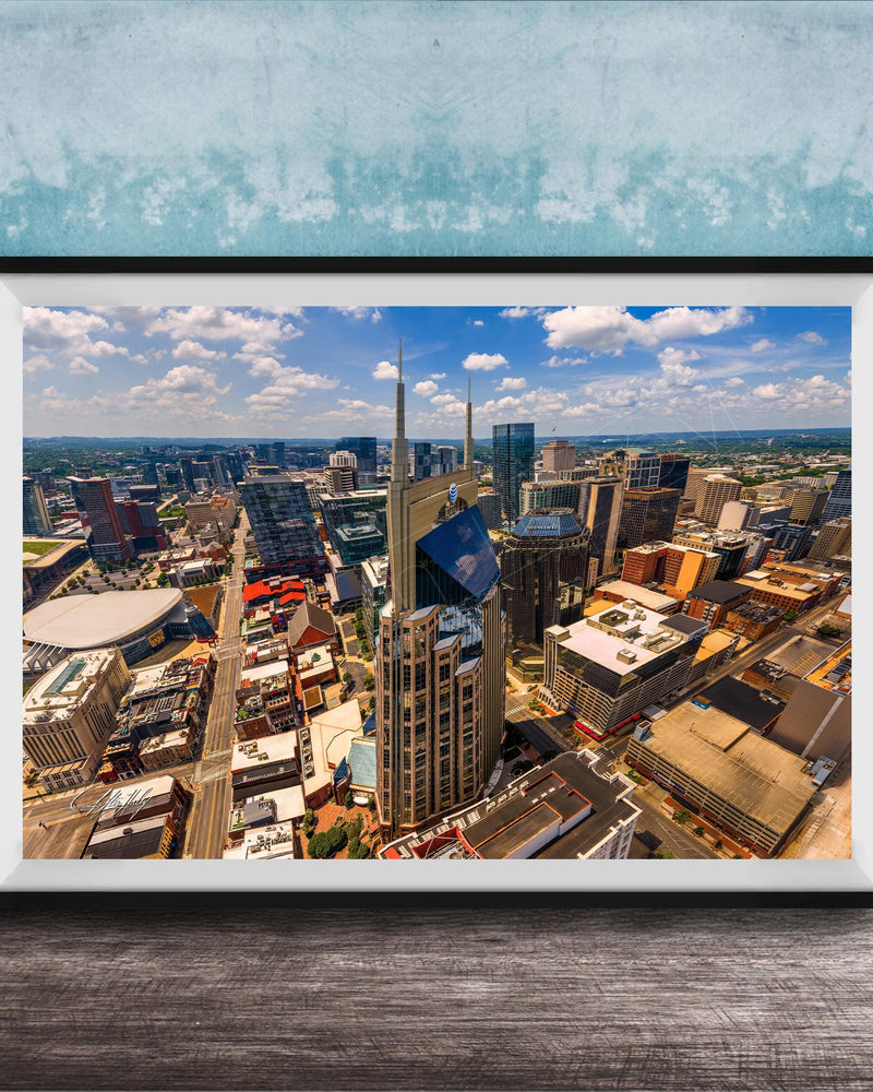 The image is a framed aerial view of a bustling city, showcasing a variety of tall buildings and skyscrapers.