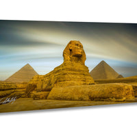 the Great Sphinx of Giza, a large limestone statue of a mythical creature, standing in the foreground with the pyramids of Giza in the background.