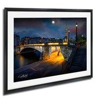 a picturesque night scene of a bridge illuminated by lights, with a full moon in the sky and a tall tower in the background.