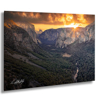 a breathtaking view of a mountainous landscape at sunset, with the sun setting behind the mountains and casting a warm, golden glow over the scene.