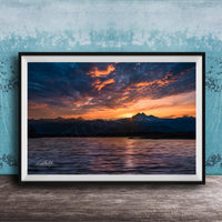 a breathtaking sunset over a mountain range, with the sun setting behind the peaks and casting a warm, golden glow across the sky.