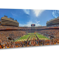 A panoramic view of a crowded football stadium with a large audience, a large field, and a scoreboard visible in the center of the image.