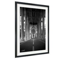 A black and white photograph of an architectural structure with arched doorways and columns, creating a sense of depth and grandeur.