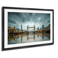 A framed photograph of the Tower Bridge in London, England, with the city's skyline and the River Thames in the background.