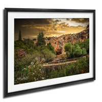 a picturesque landscape with a rocky cliff, lush vegetation, and a vibrant sky with clouds.