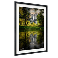 a serene landscape with a waterfall cascading down a rocky cliff, surrounded by lush greenery and reflected in a calm body of water.
