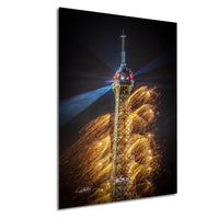 a tall tower with a pointed top, surrounded by a vibrant display of fireworks in the night sky.