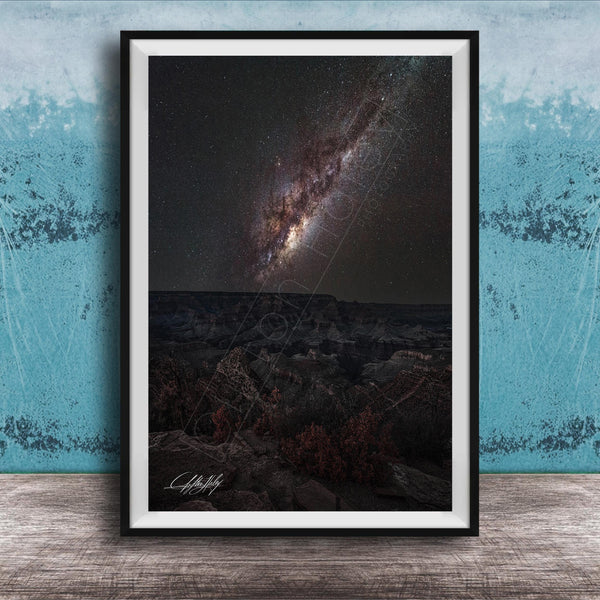 The image is a framed photograph of a night sky with a distant galaxy, set against a dark background.