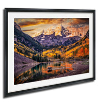 a serene mountain landscape with a lake in the foreground, surrounded by trees with autumn foliage. The sky is filled with clouds, creating a dramatic backdrop for the scene.