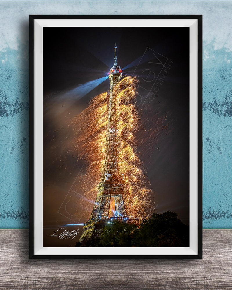 a tall, illuminated tower with a bright light at the top, surrounded by a colorful display of fireworks.