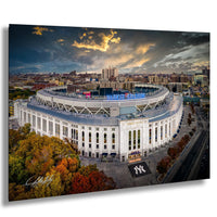 the Yankee Stadium, a large white stadium with a curved roof, surrounded by a city skyline and a dramatic sky with clouds and sun.