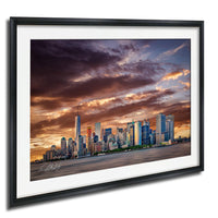 a city skyline at sunset, with the silhouettes of tall buildings against a dramatic sky filled with clouds and vibrant colors.