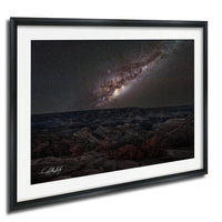 a breathtaking view of a starry night sky over a rugged, mountainous landscape.