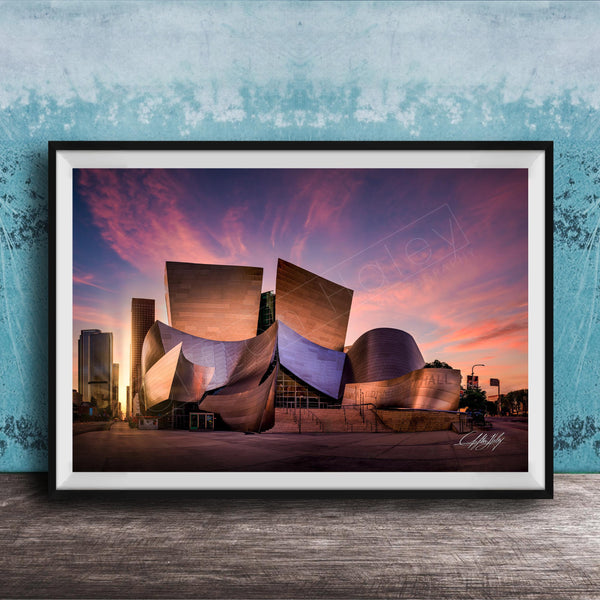 A framed photograph of the Guggenheim Museum in Bilbao, Spain, at sunset, with the distinctive curved architecture of the building illuminated against a colorful sky.