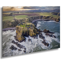 a picturesque coastal scene with a castle perched atop a rocky outcrop, overlooking the crashing waves of the sea.
