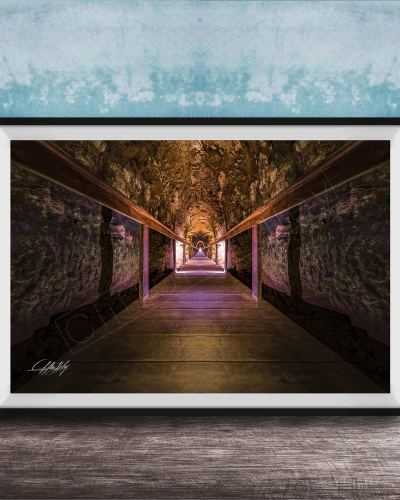 a long, dimly lit tunnel with a wooden floor and walls, creating a sense of depth and mystery.
