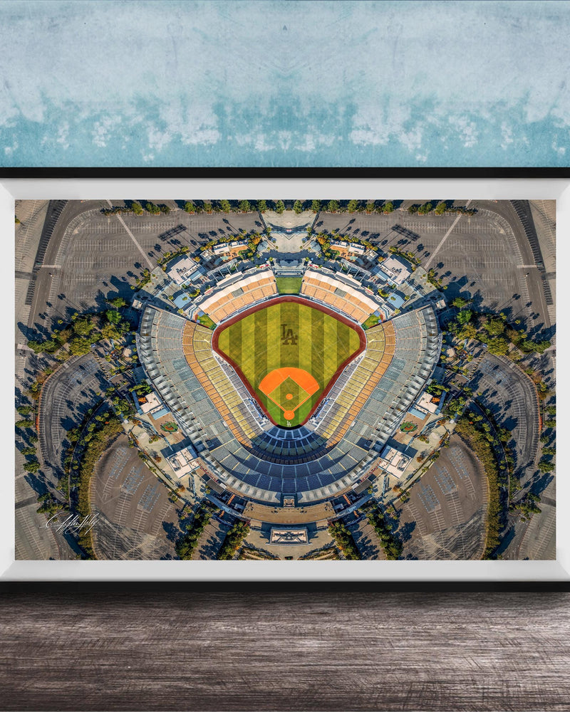 The image is an aerial view of a baseball stadium, featuring a large field surrounded by parking lots and other structures.