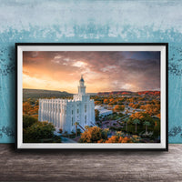 A framed photograph of a white temple with a tower, set against a colorful sunset sky with clouds and mountains in the background.