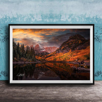 a serene mountain landscape with a lake reflecting the vibrant colors of the sky and surrounding trees.