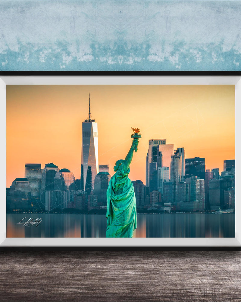 A framed photograph of the Statue of Liberty in New York City, with the city skyline in the background.