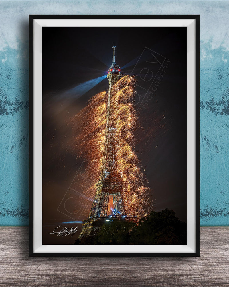 a tall, illuminated tower with a fireworks display lighting up the night sky.