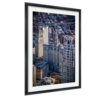 The image is a framed aerial view of a densely populated city with numerous tall buildings and skyscrapers.