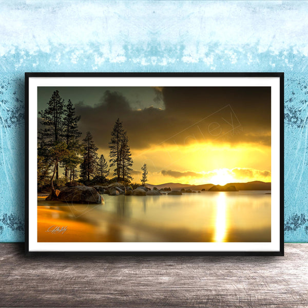 A framed photograph depicting a serene landscape with a lake, trees, and a sunset over the water.