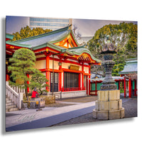 A traditional Japanese temple with a red roof and white walls, surrounded by trees and a stone lantern, with a person sitting on a bench in the foreground.