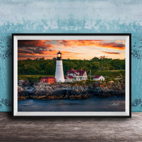 A framed photograph of a lighthouse on a rocky shore, with a colorful sunset sky in the background.