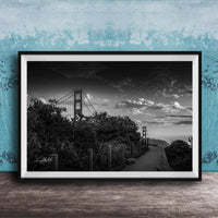 A black and white photograph of the Golden Gate Bridge in San Francisco, California, with a cloudy sky in the background.