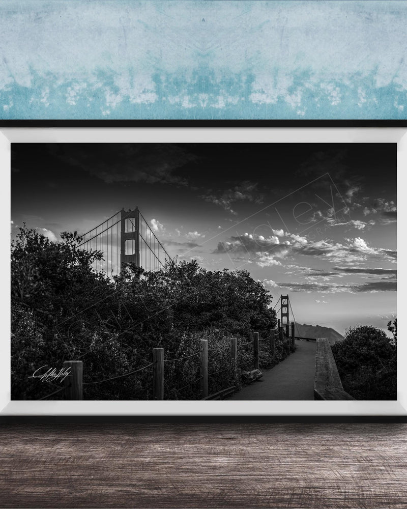 A black and white photograph of the Golden Gate Bridge in San Francisco, California, with a cloudy sky in the background.