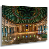 a grand, ornate mosque with a large, intricately patterned green and gold dome, a central archway, and a long, polished marble floor.